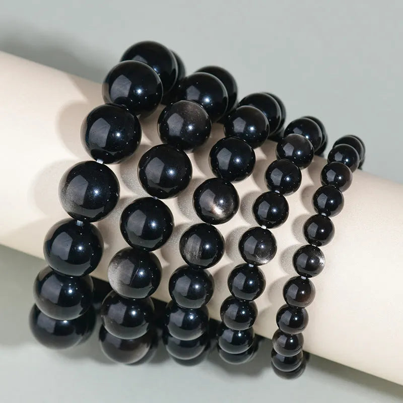 Hand-woven black obsidian bracelet showing round crystal beads in 8mm to 16mm diameter options with ethnic unisex styling