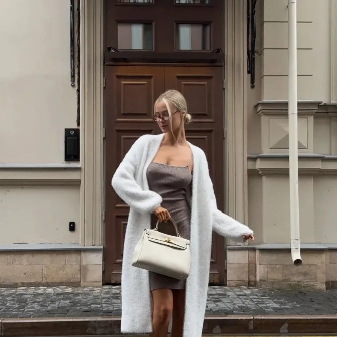 White long-line knit cardigan jacket on a hanger, showing loose fit and long sleeves.