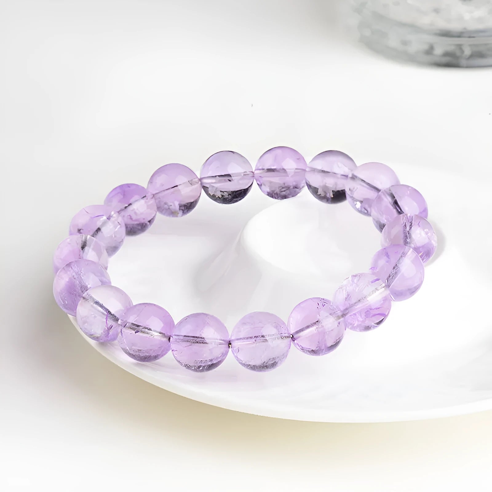 Lavender round amethyst bead bracelet with water ripple design on a wrist.