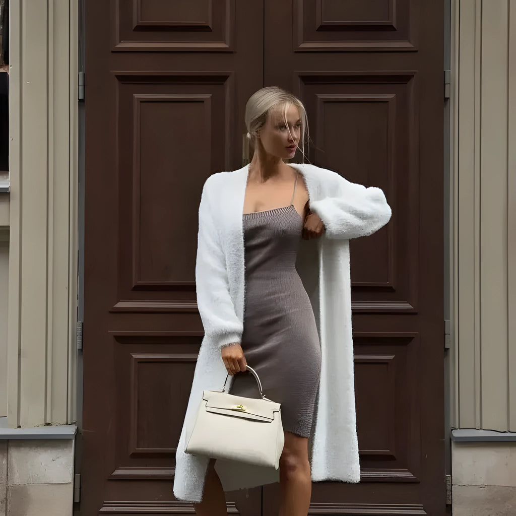 White long-line knit cardigan jacket on a hanger, showing loose fit and long sleeves.
