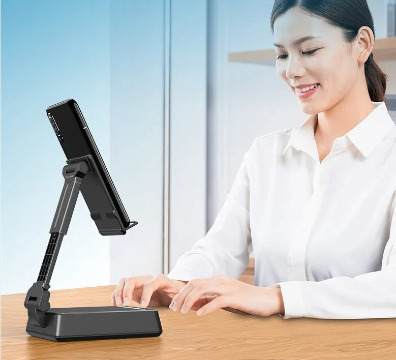 Black mobile phone broadcasting stand with integrated Bluetooth speaker on a desk.