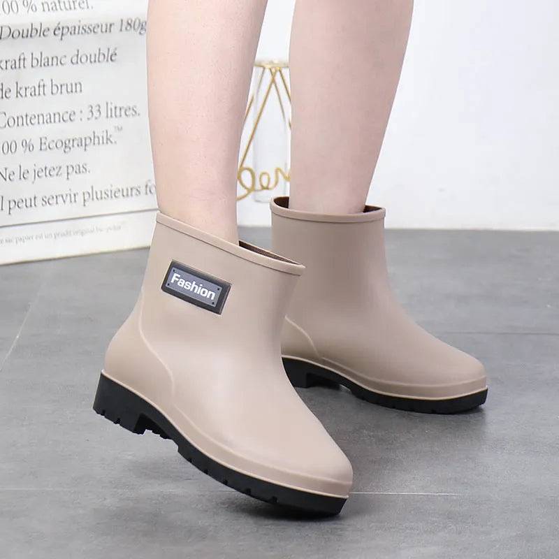 Women's mid-calf PVC rain boots in black with low heel, shown in short tube design