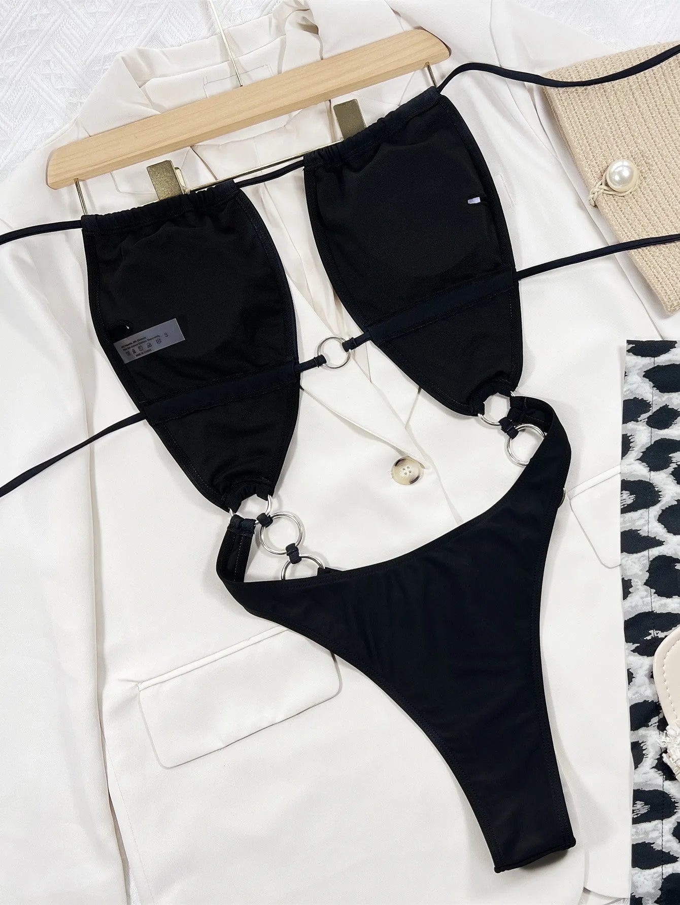 Black sleeveless one-piece swimsuit for women on a hanger
