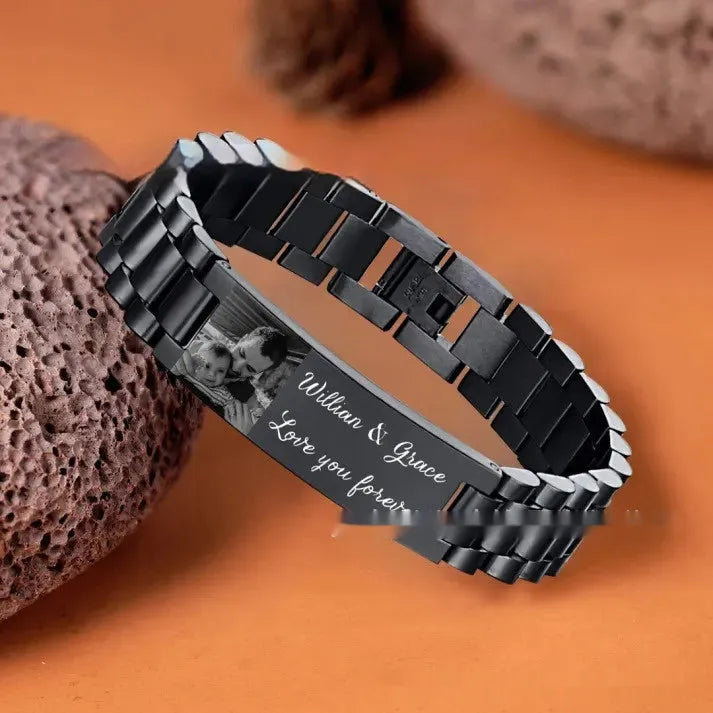 Men's stainless steel bracelet with curved heart piece featuring black electroplated lettering