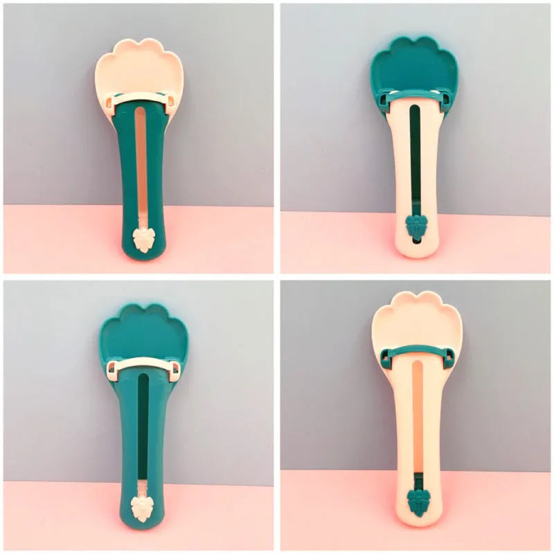 Green and pink plastic pet food squeezer feeder with a spoon-shaped dispensing end.