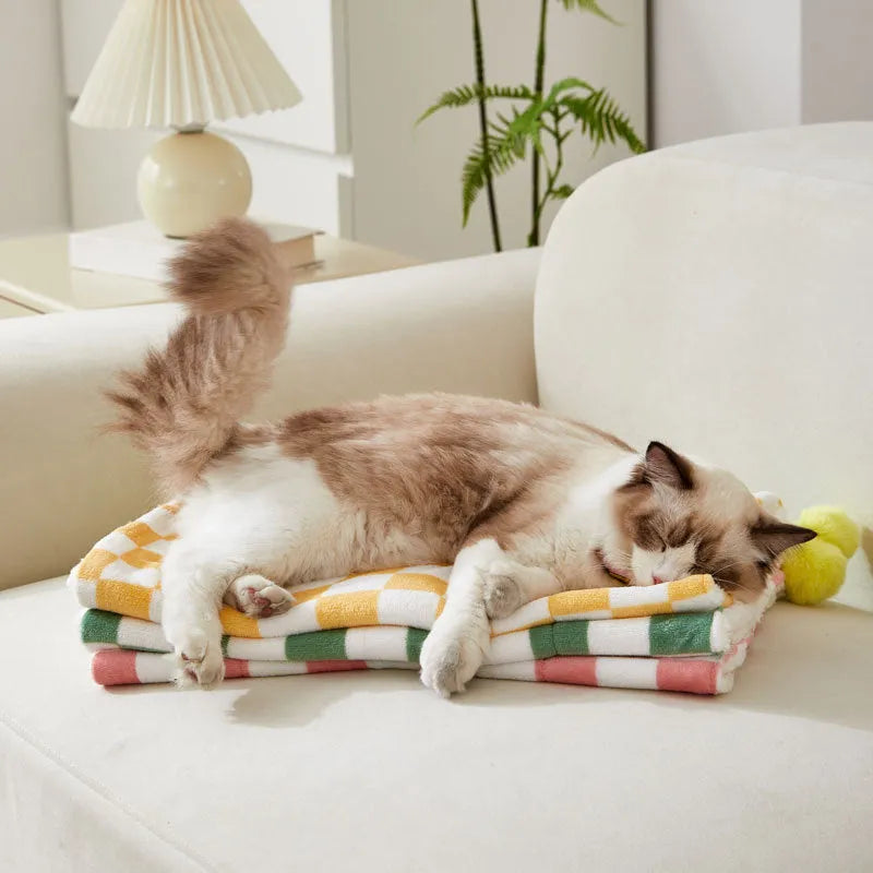 Plaid pattern pet blanket with fur ball decoration in green, pink, or yellow colours on soft fleece material