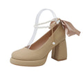 Beige women's Mary Jane shoes with a chunky block heel, ankle strap buckle, and round toe with pearl detail.
