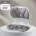 Grey memory foam seat cushion with a black fabric fixing strap on a wooden chair.