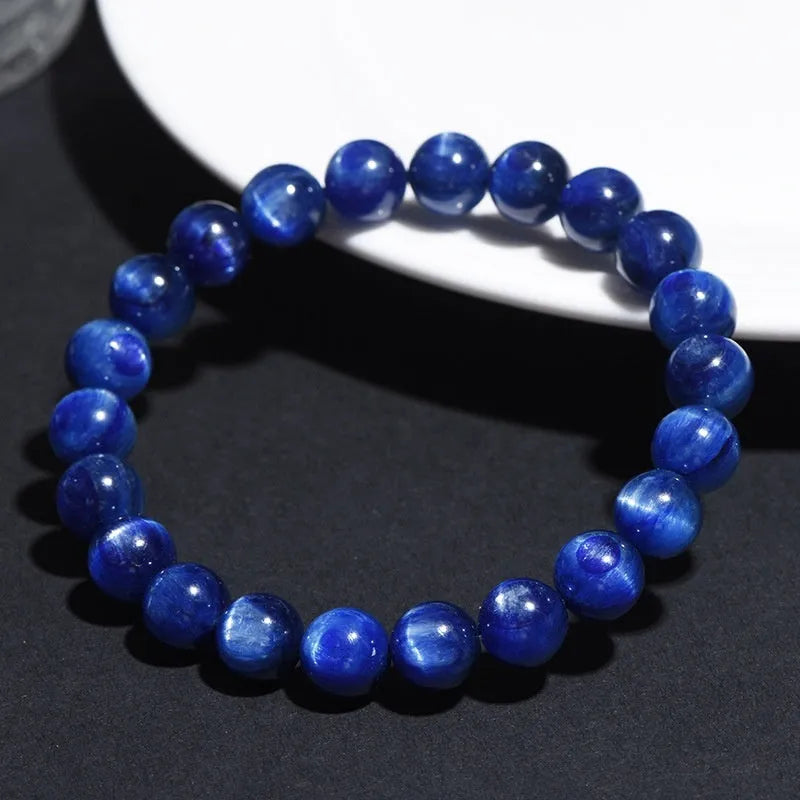 Polished blue crystal ball bracelet with geometric beads and Ruyi design on a white background.