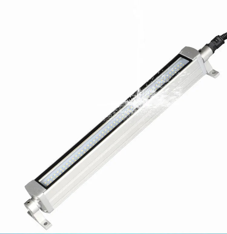 Long, rectangular LED work light with aluminium body and tempered glass front, mounted with a bracket for CNC machine tools.