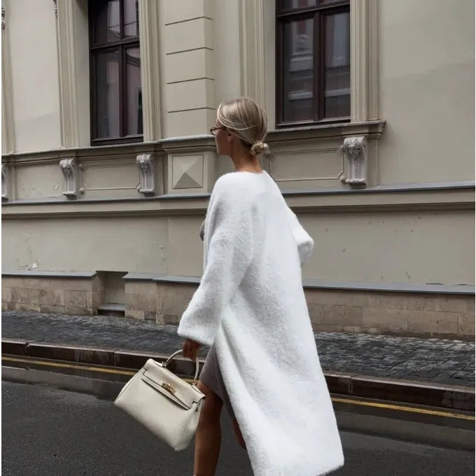 White long-line knit cardigan jacket on a hanger, showing loose fit and long sleeves.