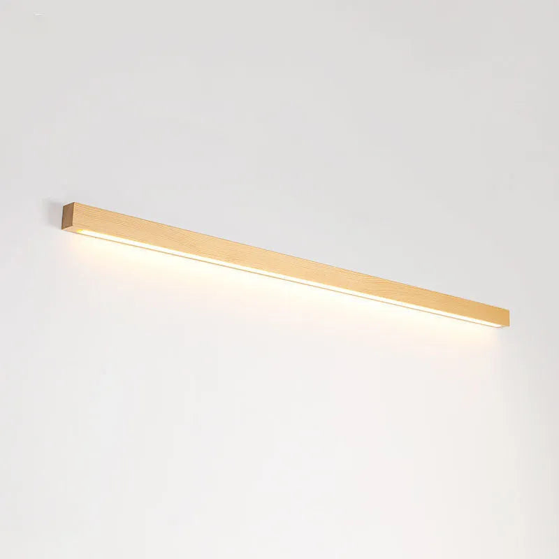Walnut-coloured linear wood and acrylic strip wall lamp mounted on a light wall.