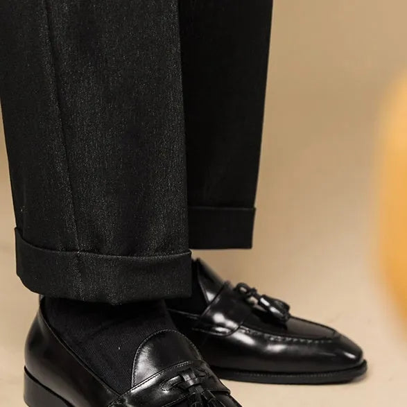 Men's black polished leather tassel loafers with a pigskin lining and rubber sole