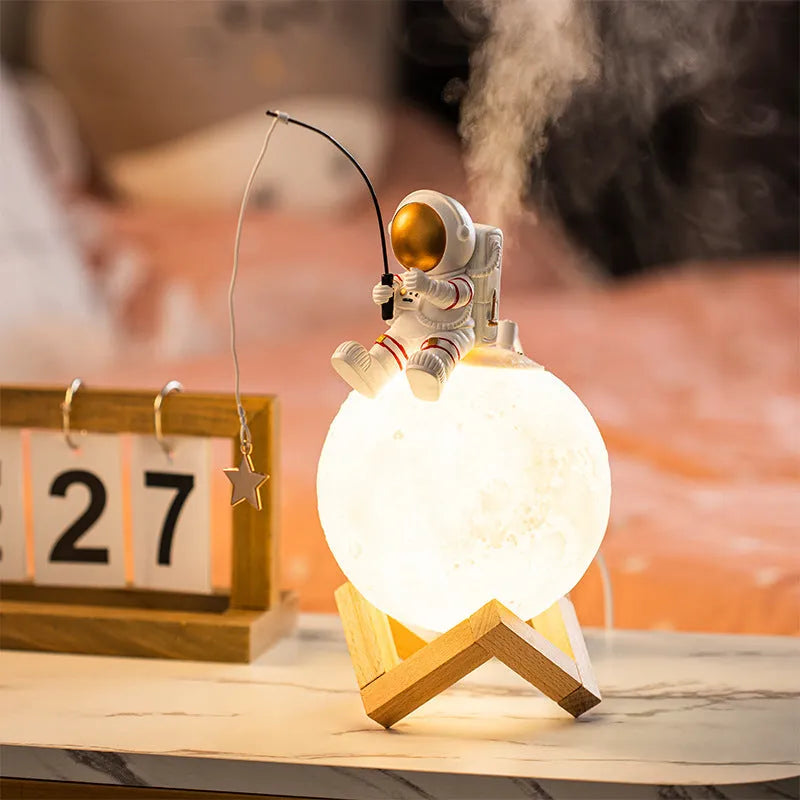 Gold resin astronaut figurine humidifier night light with wood base, 28 cm tall, on a desk