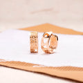 Rose gold hollowed-out heart drop earrings with a circular silhouette on a white background.