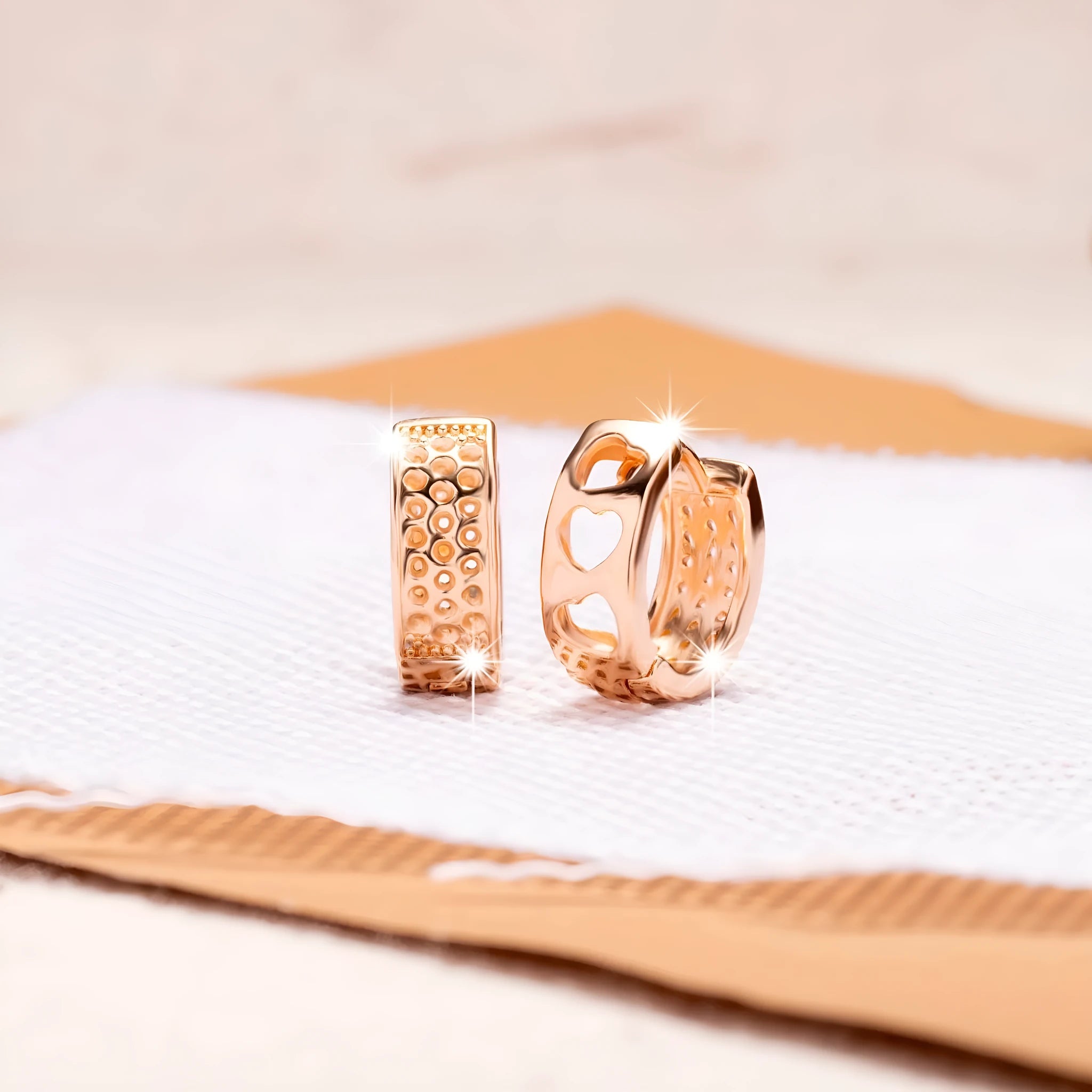 Rose gold hollowed-out heart drop earrings with a circular silhouette on a white background.