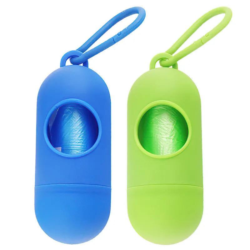 A small, square black plastic dog poop bag holder with a metal hook and Velcro strap.