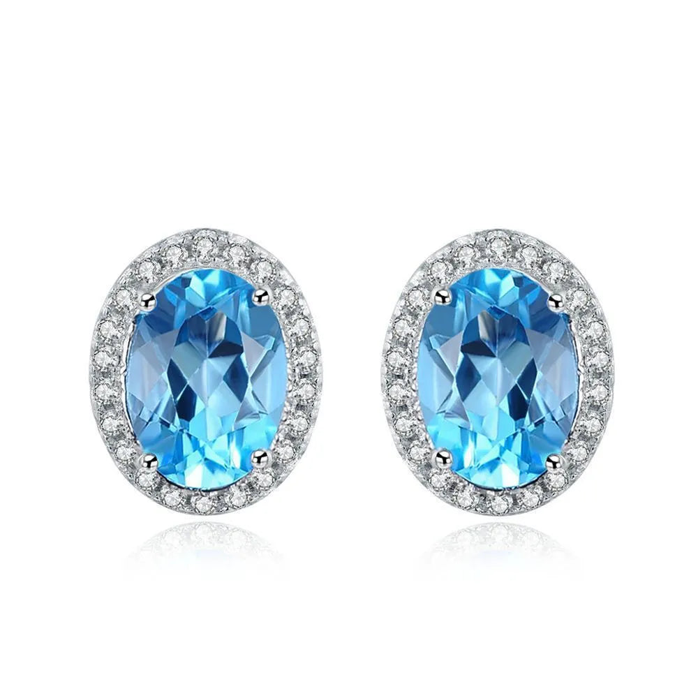 Women's 925 sterling silver and blue topaz four-piece jewellery set with geometric design, showing earrings, ring, necklace, and pendant.