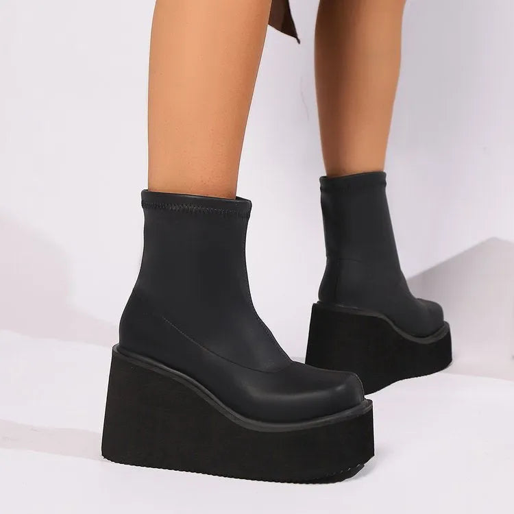 Plus size women's black faux leather wedge heel ankle boots with round toe on a waterproof platform sole.