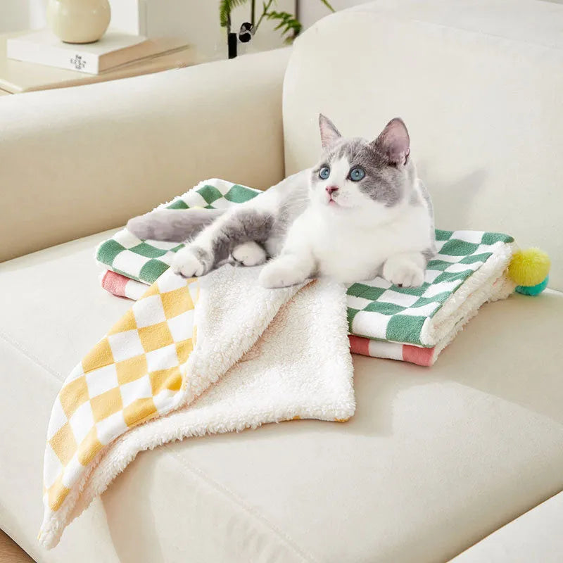 Plaid pattern pet blanket with fur ball decoration in green, pink, or yellow colours on soft fleece material