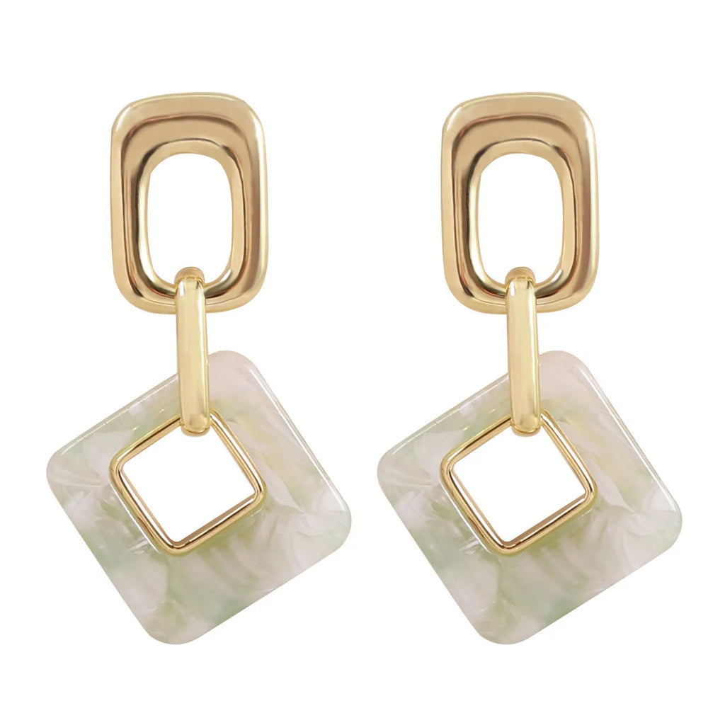 A pair of hollow geometric square earrings with a chamfered pattern, shown in an electroplated finish.