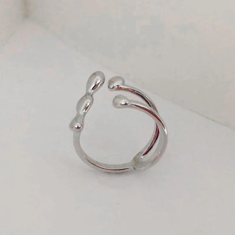 Brass opening ring with spherical details in gold or silver colour on display surface