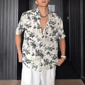 Men's loose black floral print short sleeve casual shirt on a hanger