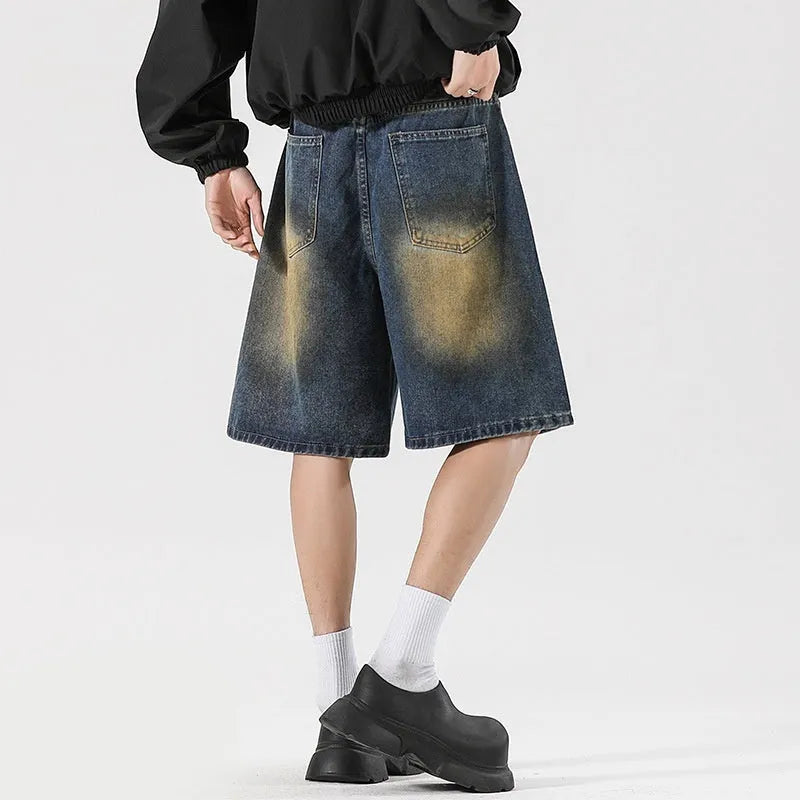 Man wearing loose fit retro blue ripped jeans with distressed details on a street style background.