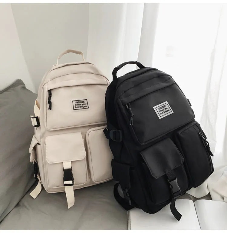 Black and white soft nylon student backpack with laptop compartment and external pockets.