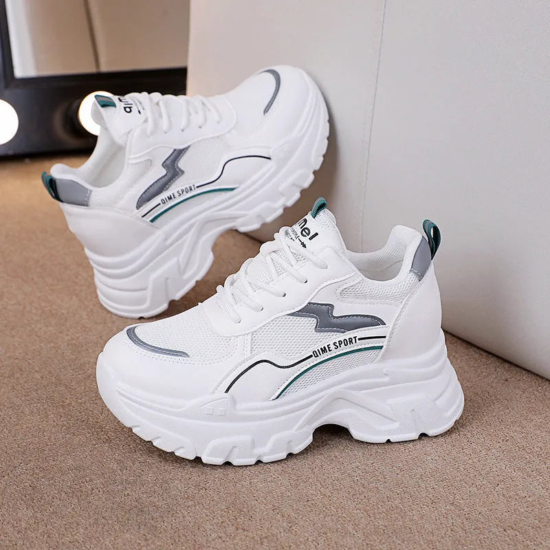 Women's white and beige low-top lace-up sports shoes with a breathable mesh upper.