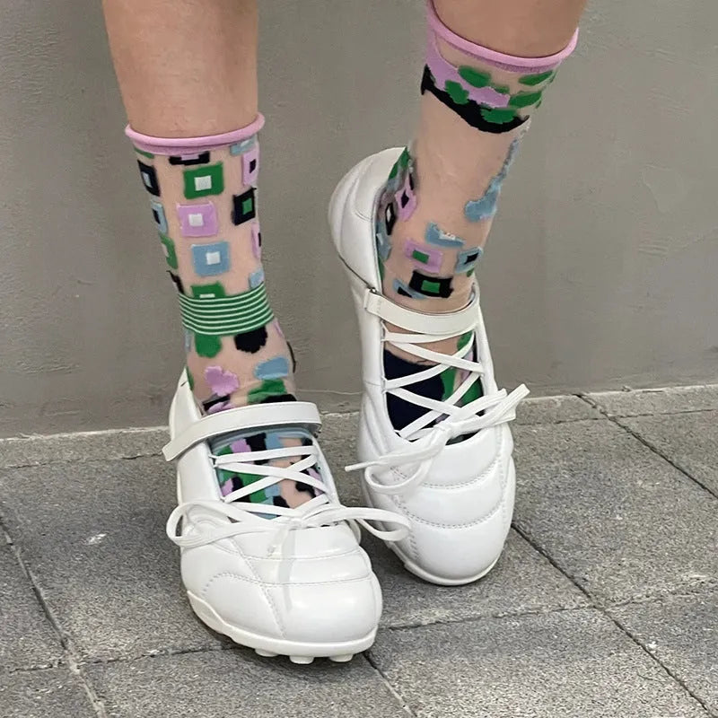 Women's silver sports shoes with a front lace-up bow and a mid heel on a white background.