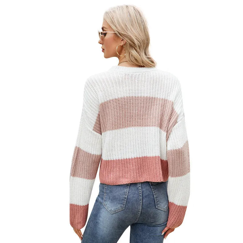 Women's short-length loose striped acrylic pullover sweater on a hanger.