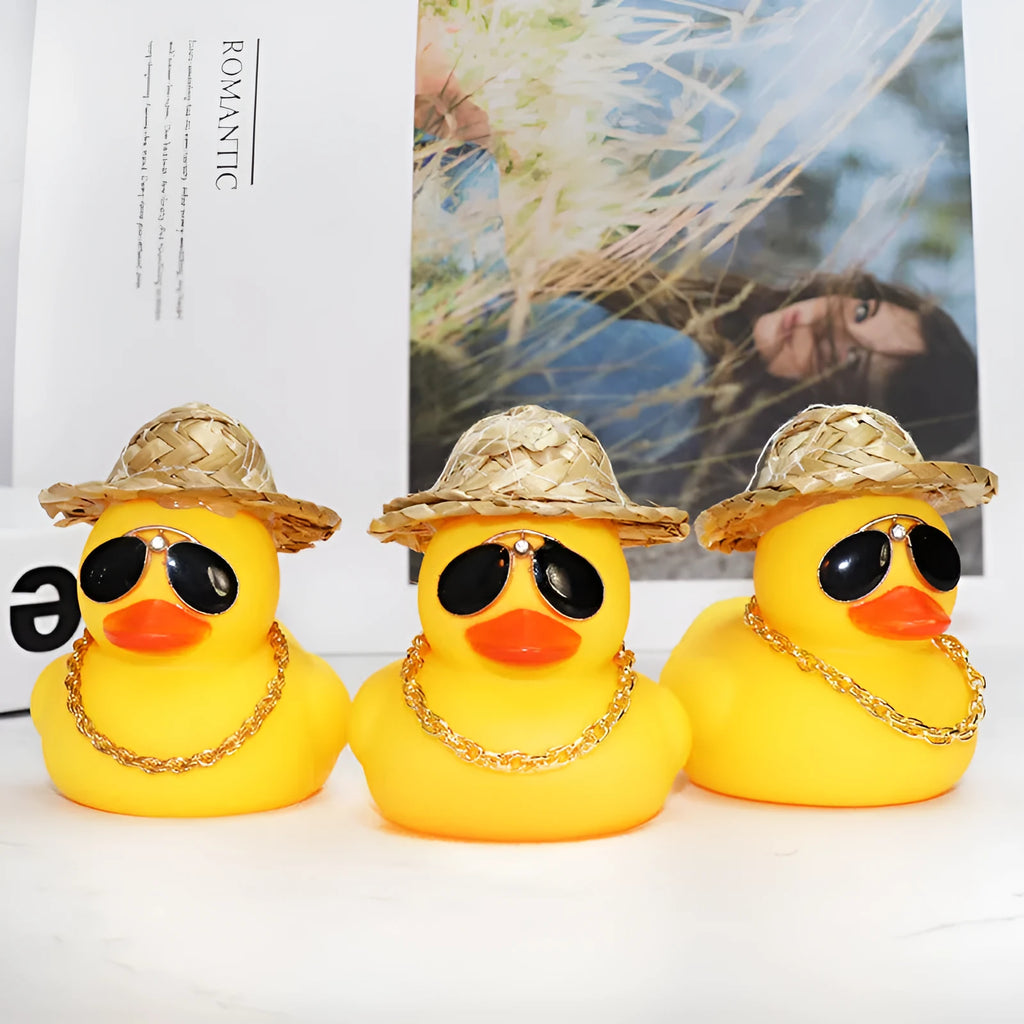 Matte yellow cartoon duck wearing a straw hat car ornament on a dashboard.