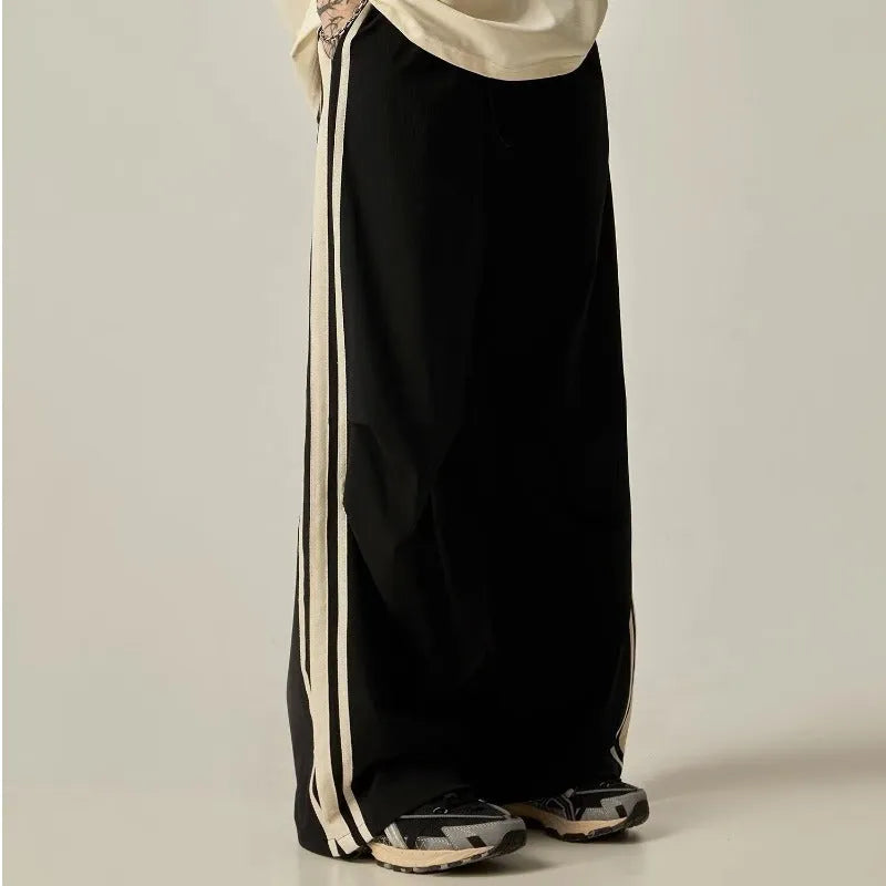 Man wearing black high-waist wide-leg climbing trousers in a casual setting