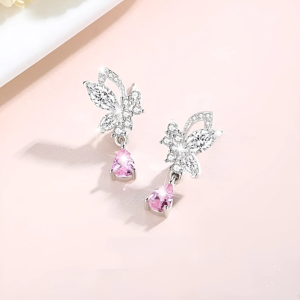 A pair of silver butterfly stud earrings with clear crystal details on a white background.