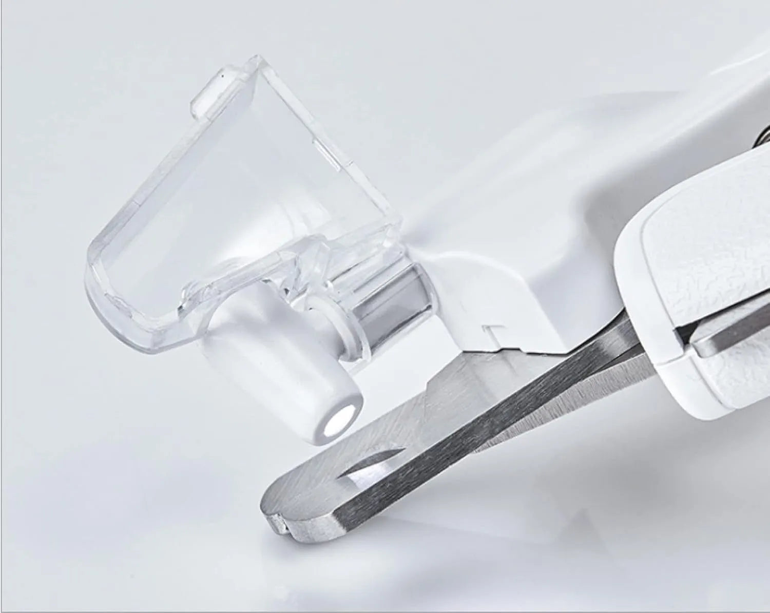 White pet nail clippers with LED light, transparent anti-splash guard, and leather-like handle on a table