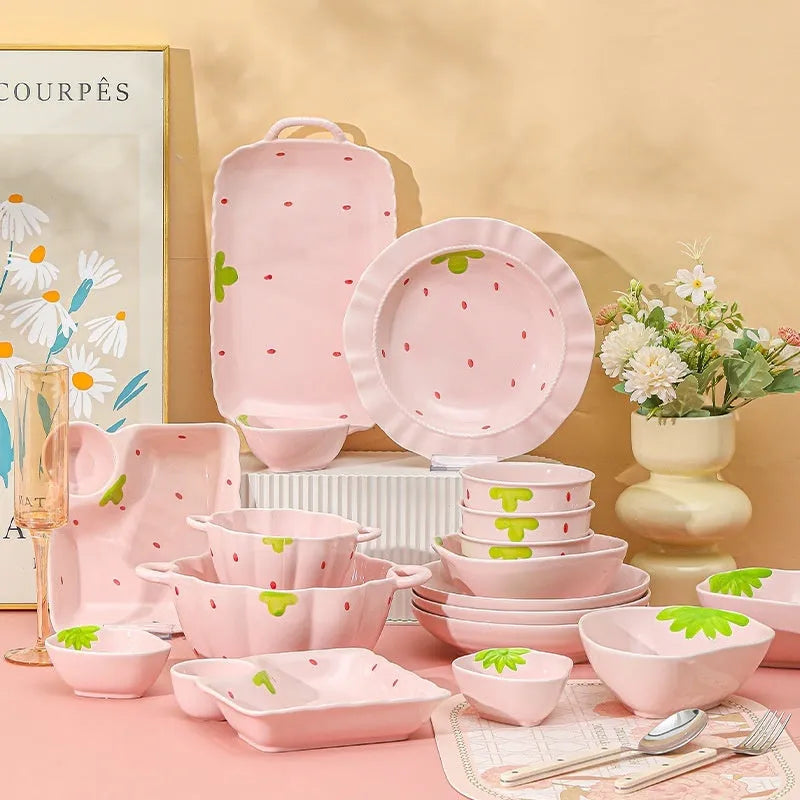 Porcelain dinnerware set with strawberry design: bowl, plate, and twist-handle spoon.