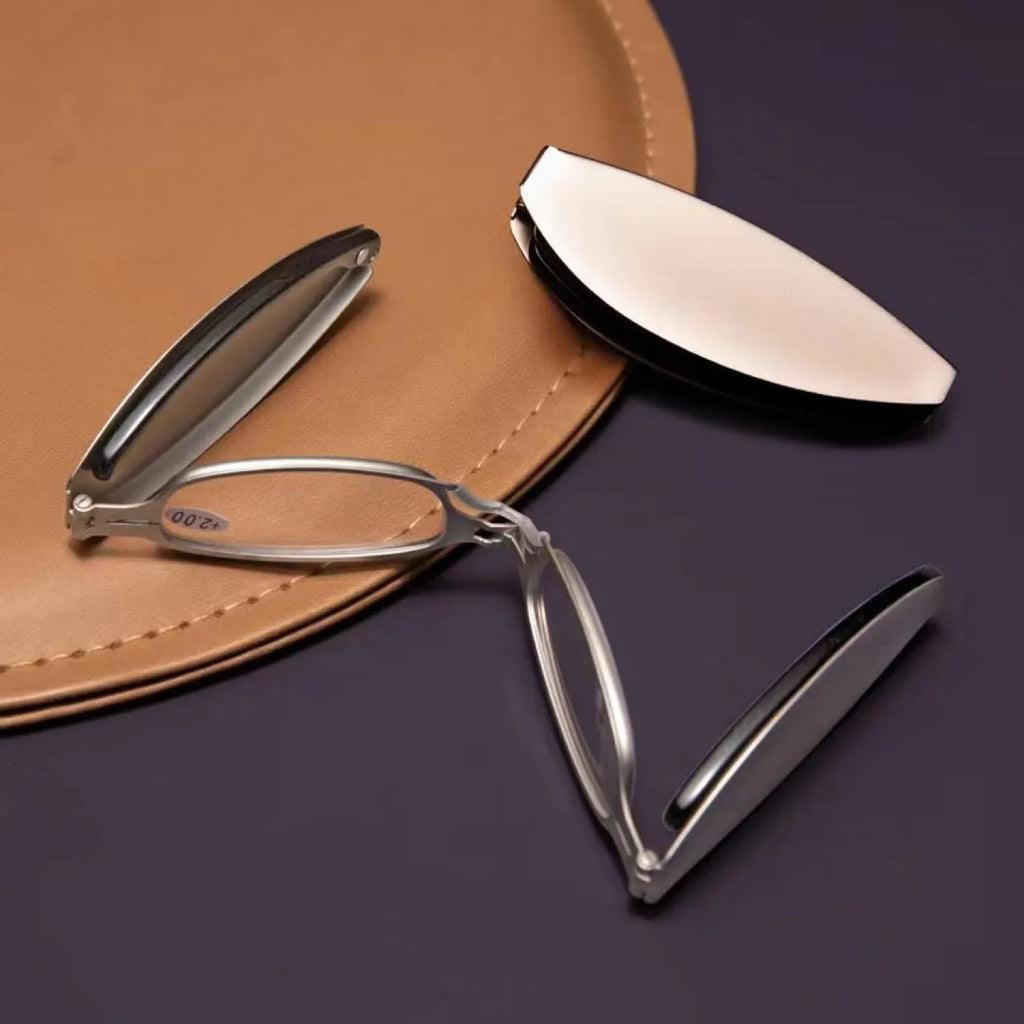 Folding reading glasses with retro metal frame in black and silver colours, showing compact folded size