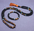 Close-up of black agate and tigereye geometric bead bracelet and necklace set on neutral background