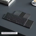 Black folding Bluetooth keyboard shown in open position next to mobile phone