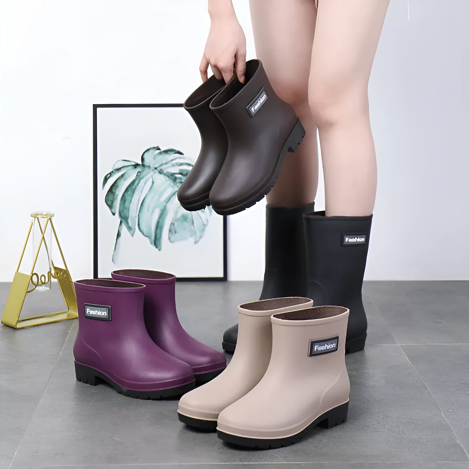Women's mid-calf PVC rain boots in black with low heel, shown in short tube design