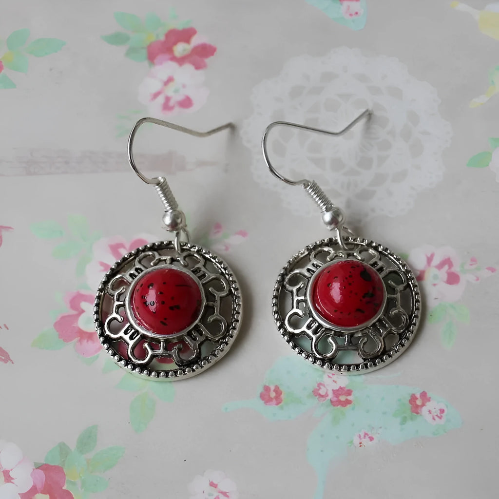 Handmade geometric flower disk earrings in Tibetan silver and turquoise, showing totem patterns.