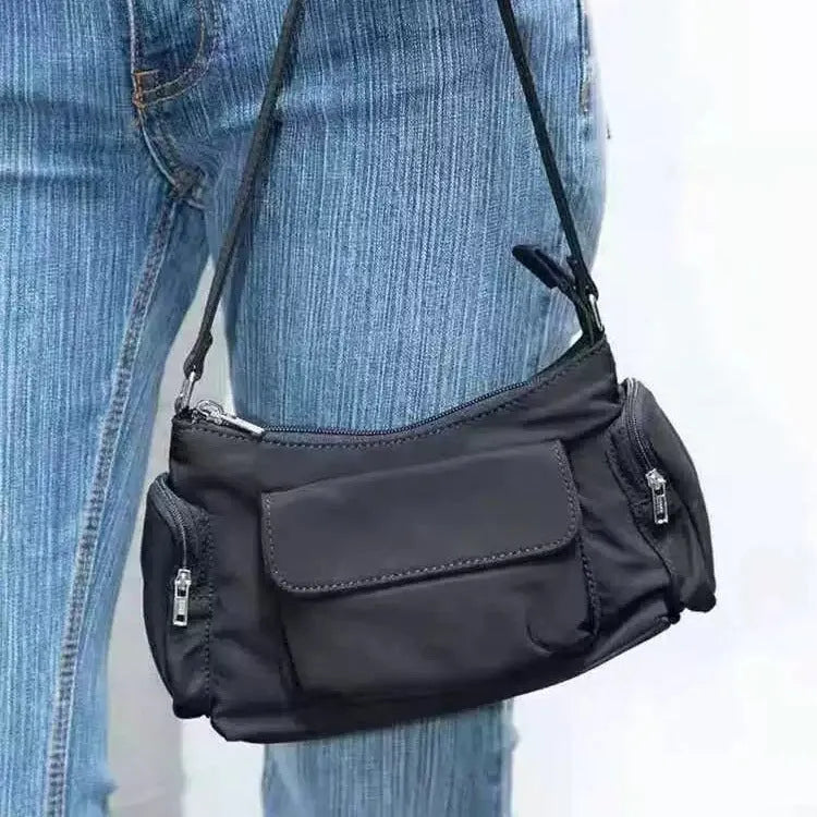 Black nylon lightweight shoulder bag with double pockets and side line detailing.
