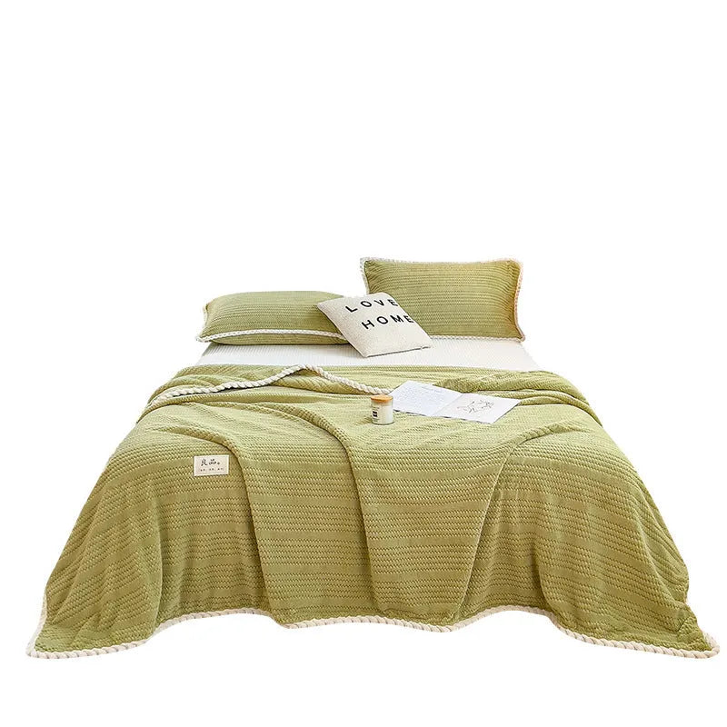 Solid colour jacquard milk velvet blanket in cream white on a bed with Nordic-style decor