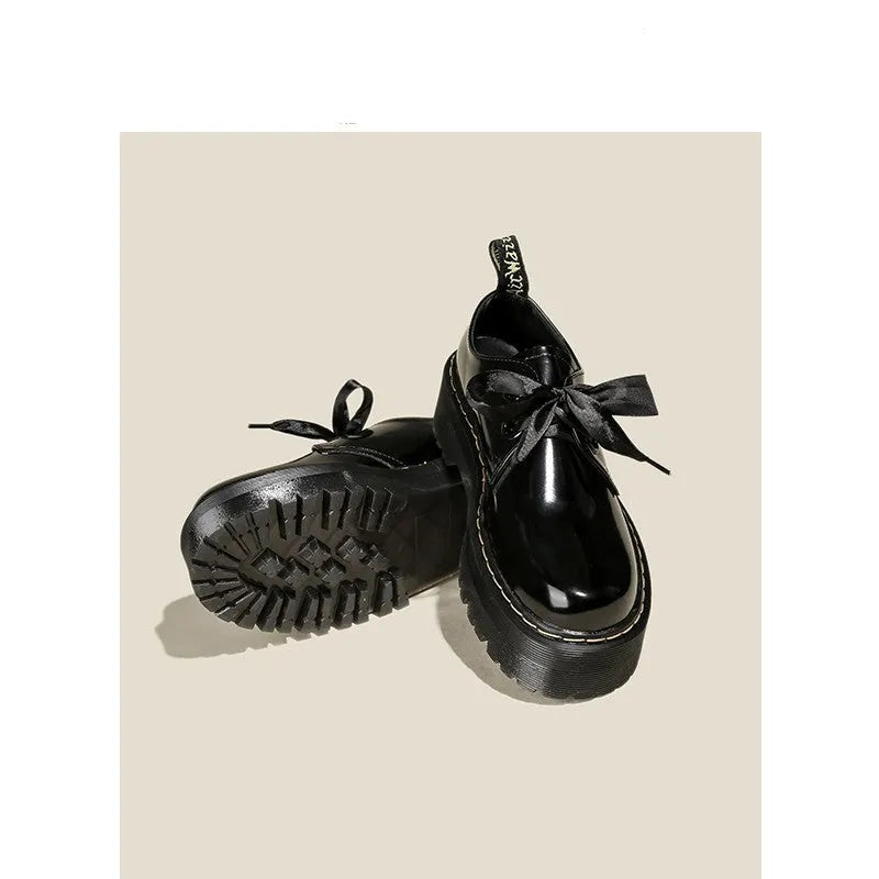 Women's white and black leather shoes with thick soles, ribbon and cross-strap design, and laced closure.
