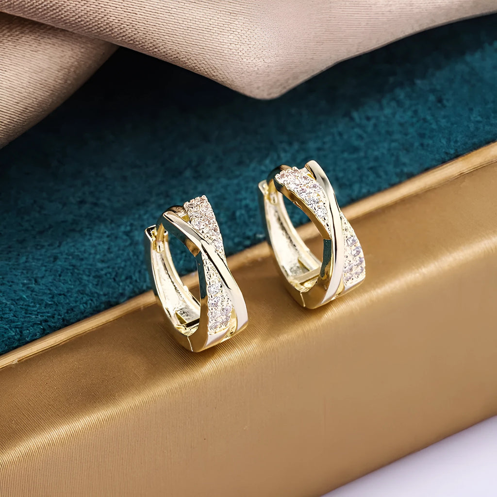 A pair of 14K yellow geometric shaped stud earrings on a plain background.