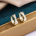 A pair of 14K yellow geometric shaped stud earrings on a plain background.