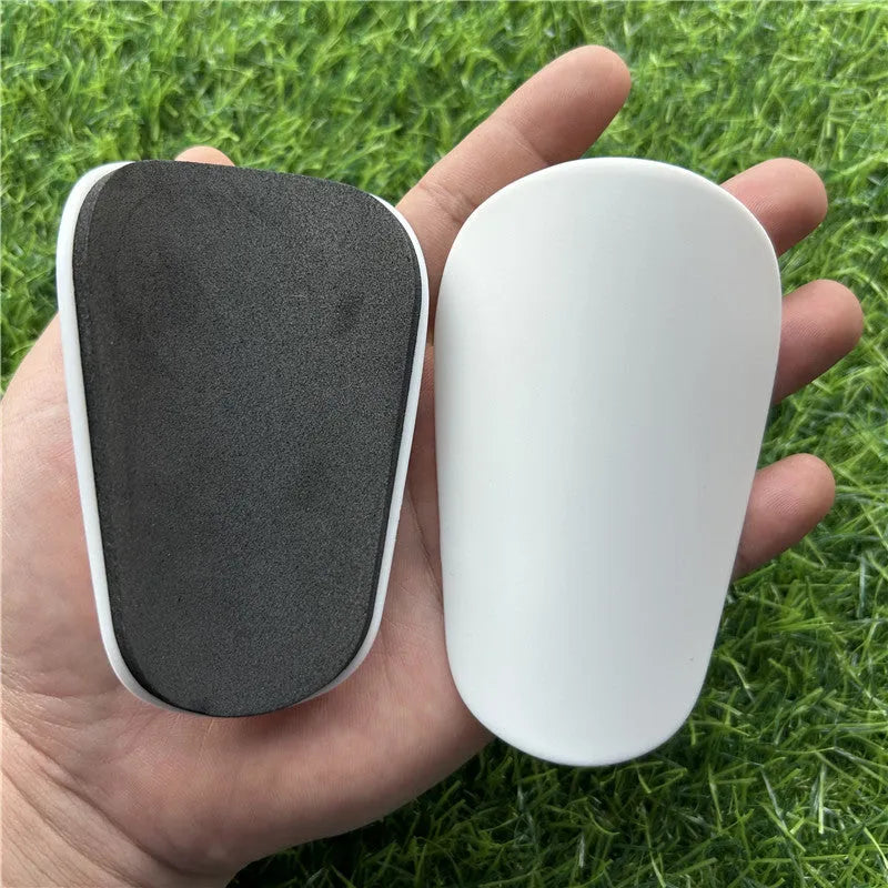Extra small plastic football shin guards measuring 8cm by 5cm with elastic straps