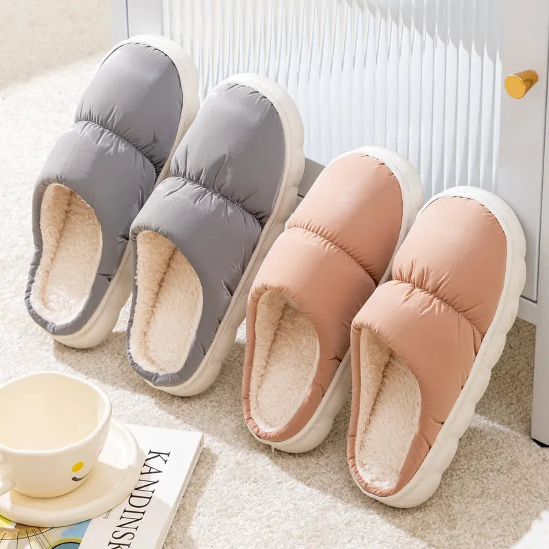 Pair of down cotton winter slippers with artificial leather upper, plush lining, and thick rubber sole.