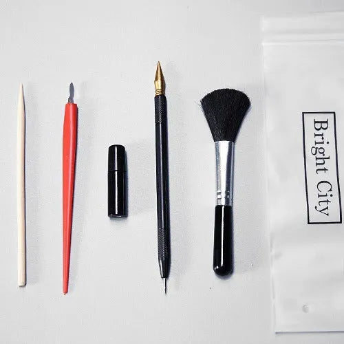 Scratch art painting kit with tools, healing pen, photo frames, and gift bag on a white card surface.